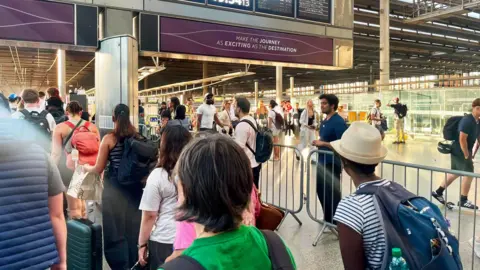 People stood in busy railway station