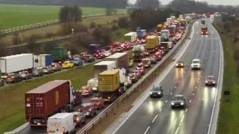 Queuing vehicles including vans, cars and HGVs on the A14. 