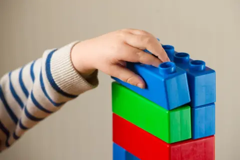 PA Pre-school child playing with building blocks