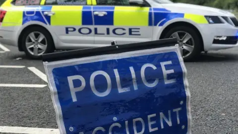 Yellow, blue and white police car and blue and white police accident sign