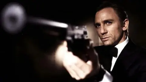 Daniel Craig as 007, pointing a gun