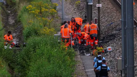 Reuters Rail workers investigate damage to cables