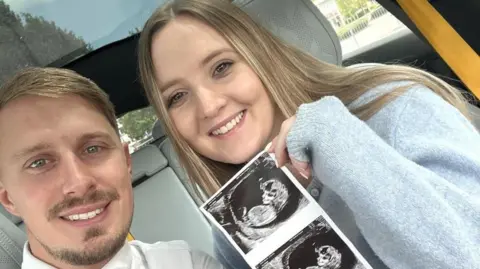 Rachel Evans Rachel Evans and partner Pete Walker sit in a car holding their baby scan pictures.