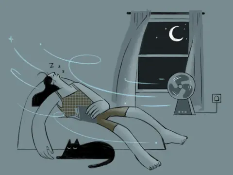 Stylised illustration of a person asleep in a chair at night while a fan blows cool air across the room. The person is reclining with eyes closed and “Z” symbols above the head, wearing a checked sleeveless top and shorts. Curved blue lines show airflow moving around the room. A black cat lies curled up on the floor beneath the chair. In the background, an open-curtained window reveals a dark night sky with a crescent moon and stars. A small electric fan sits on a table beside the window, plugged into a wall socket. The image uses muted grey, black, olive green and pale blue tones.