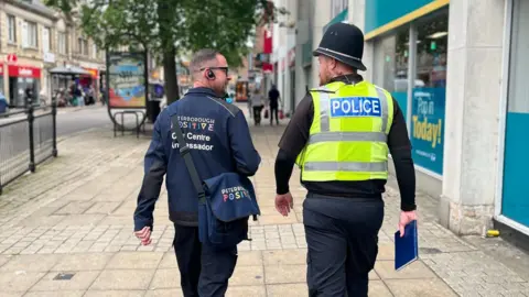 Peterborough Positive Picture of Terry and PC Jay walking together- taken from behind 