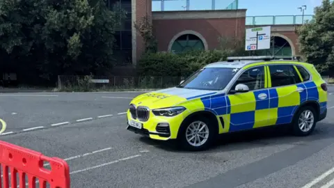 George King/BBC Seorang petugas dan dua mobil polisi di Cordon di Ipswich