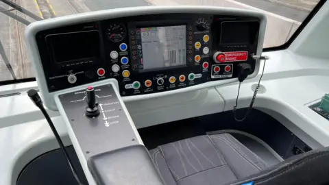 The interior of the Very Light Rail (VLR) tram vehicle on tracks in Coventry city centre.