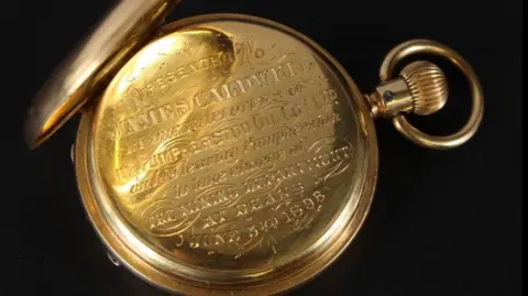 John Nicholson's A gold pocket watch with an inscription on the back of it.