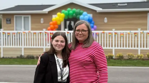 Hannah Roberts standing next to her mother Gail Iredale outside their new respite lodge at Mercia Marina in Willington
