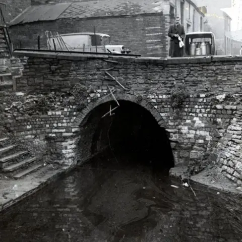 Cardiff Story Museum A black and white photograph of one of Cardiff's canals that has since been built over.