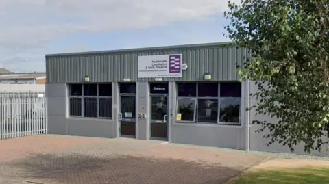 Google A Google Street View of Humberside, Lincolnshire and North Yorkshire probation office in Grimsby. It shows the outside of a grey office building. There is a tree on the right.