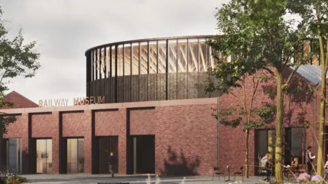 An architect's impression of a museum building. The lower section is a red-bricked building with a sign reading 'RAILWAY MUSEUM' above the doors. Above is a round building in black and glass panels. There are people walking and sitting at tables under trees in the foreground.