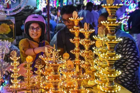 Debarchan Chatterjee/NurPhoto via Getty Images People buy decorative lights ahead of the Diwali festival celebration in Kolkata, India, on October 12, 2025.