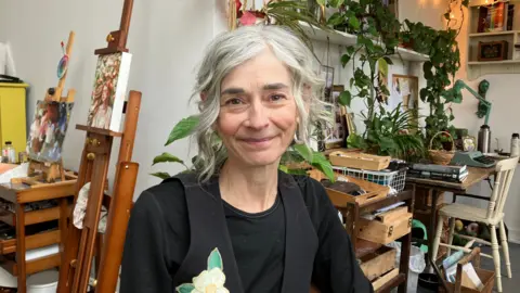 Wendy Robinson sat in her artist's studio, smiling at the camera