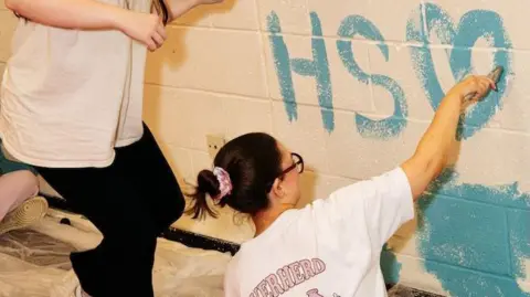 EARNT girl painting a wall.