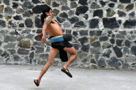 AFP A man plays a pre-Columbian ballgame called "Ulama" -in Nahuatl indigenous language- which rule is to hit a "Ulamaloni" (solid rubber ball) with the hip or shoulder, during a match at the FARO Poniente cultural centre in Mexico City on August 21, 2019