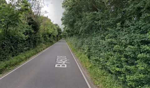 Google Maps A stretch of rural road with hedges either side.