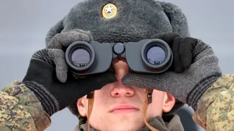 TASS/Getty Images A serviceman of the Russian Southern Military District's 150th Rifle Division looks through binoculars during a military exercise at Kadamovsky Range, Rostov region, 27 January