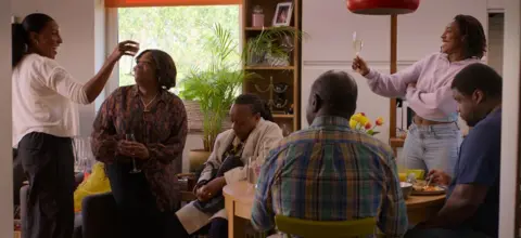 Studio Canal Still image from the film Hard Truths showing characters raising a glass as one delivers a toast