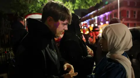 Reuters Protester in discussion with a Muslim woman