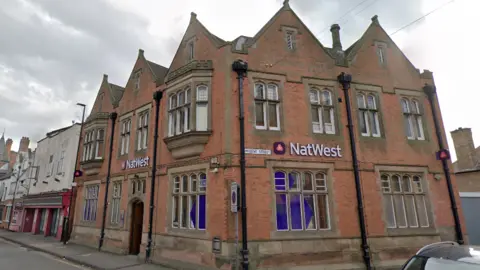 The exterior of Long Eaton Natwest, taken from Google Streetview. It is a red brick building with tall narrow windows.