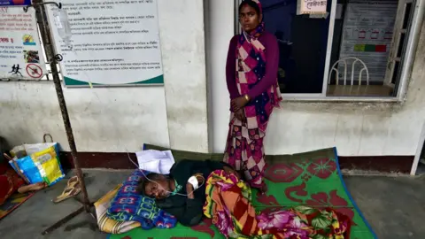 Reuters The wife of a tea plantation worker, who consumed bootleg liquor, looks on