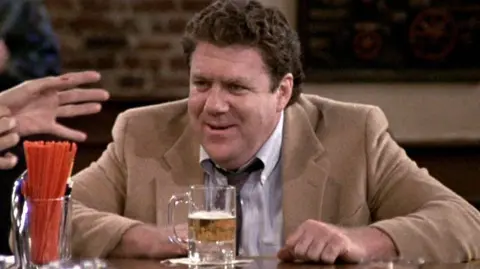 Getty Images George Wendt as Norm Peterson, sitting at the bar with a beer