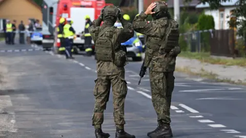 Reuters Polish Army and emergency services inspect the site after a Russian drone damaged the roof of a residential building in Wyryki, eastern Poland