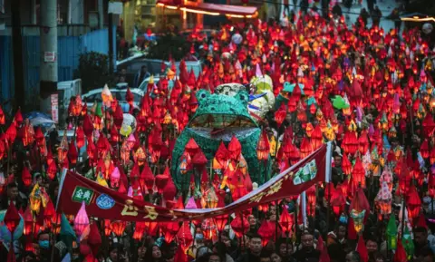 AFP People parade with frog-shaped lanterns during the Qima Festival on February 23, 2024 in Nanchong, Sichuan Province of China. Local people have the tradition to send frog lanterns to the river bank ahead of the Lantern Festival to wish for good health and safety