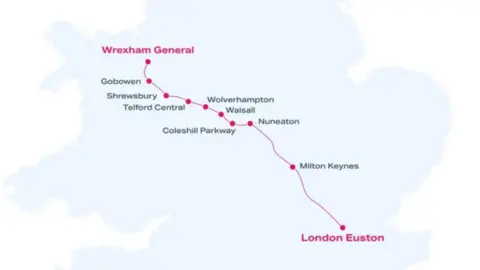 WSMR A map of Britain with a pink line showing the route of a planned rail service between Wrexham and London, with station names picked out with pink dots