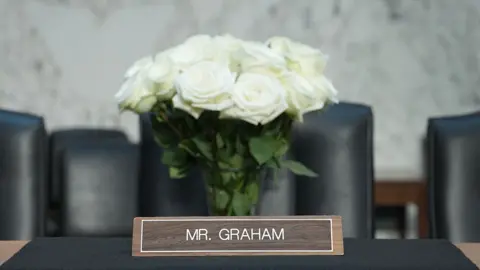 A black drape and flowers are placed at the seat of late Senate Judiciary Committee member US Senator Lindsey Graham.