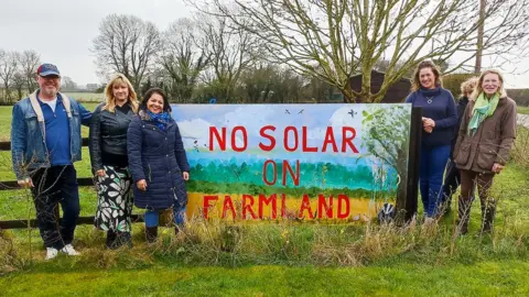 Ruchira Yarsley Six people standing by a banner