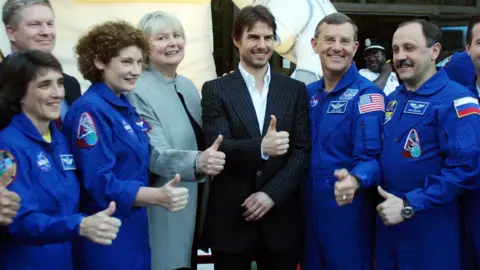 Getty Images Cruise posed with astronauts after narrating a documentary about the ISS in 2002