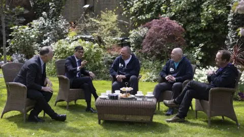 Simon Dawson/No 10 Downing Street Prime Minister Rishi Sunak chats to the 3 Dads in the garden of 10 Downing Street