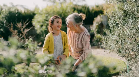 Older woman with a young girl in a garden.