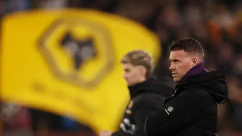 Reuters Wolverhampton Wanderers manager Rob Edwards looks on and a Wolves FC flag is blurred in the background