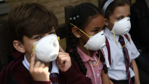 Getty Images Children wear breathing masks