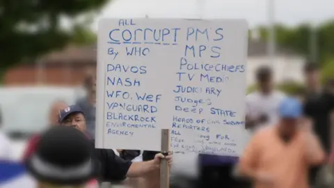 PA Media A man holding a placard