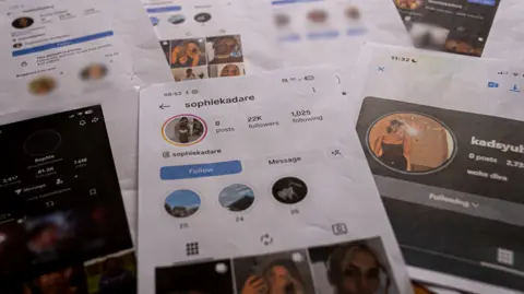 Seven A4 print outs of screenshots of the Sophie Kadare fake accouts laid out on a table. The main image in the middle shows the instagram account, which has 22k followers and eight posts, filled with Sasha's images. 