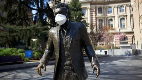 Getty Images A facemask on a statue of well known singer Claude Nougaro in Toulouse in early April