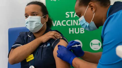 PA Media NHS staff receiving vaccination