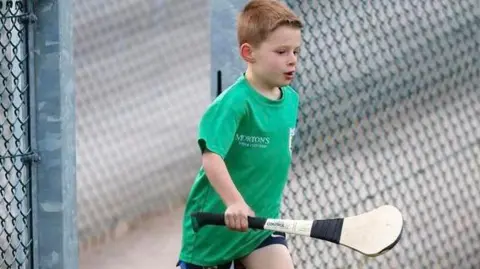 Family handout Joseph Hegarty in a green t-shirt with a hurling stick