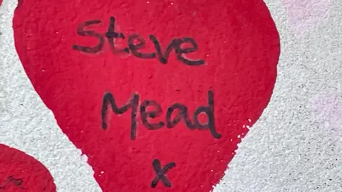 The name Steve Mead written in black ink inside a red love heart - one of 240,000 on the memorial wall