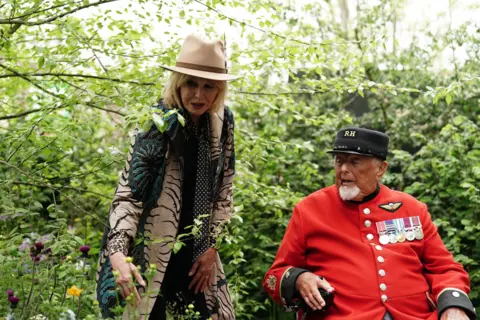 PA Media Dame Joanna Lumley with a Chelsea Pensioner, during the RHS Chelsea Flower Show press day, at the Royal Hospital Chelsea, London.