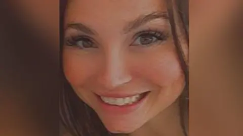 Hampshire & Isle of Wight Constabulary Samantha Murphy smiles at the camera. Only her head is visible, with long, curled eyelashes and straight, brown hair.
