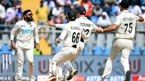 New Zealand celebrate after Ajaz Patel takes the final India wicket to seal victory