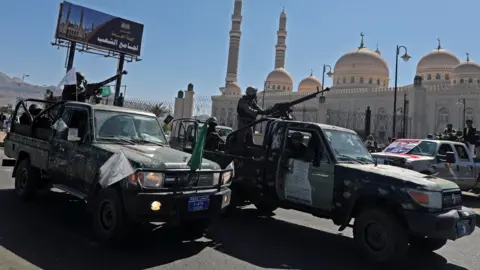 Police patrol trucks during the funeral of Houthi fighters, in Sanaa, Yemen (22 September 2020)