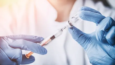 Getty Images A woman drawing something into a syringe