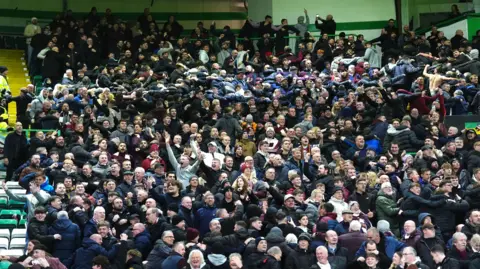 PA Media Heart of Midlothian fans celebrate their side's second goal of the game, scored by player Oisin McEntee (not pictured) during the William Hill Premiership match at Celtic Park, Glasgow.