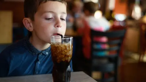 Getty Images Boy drinking coke